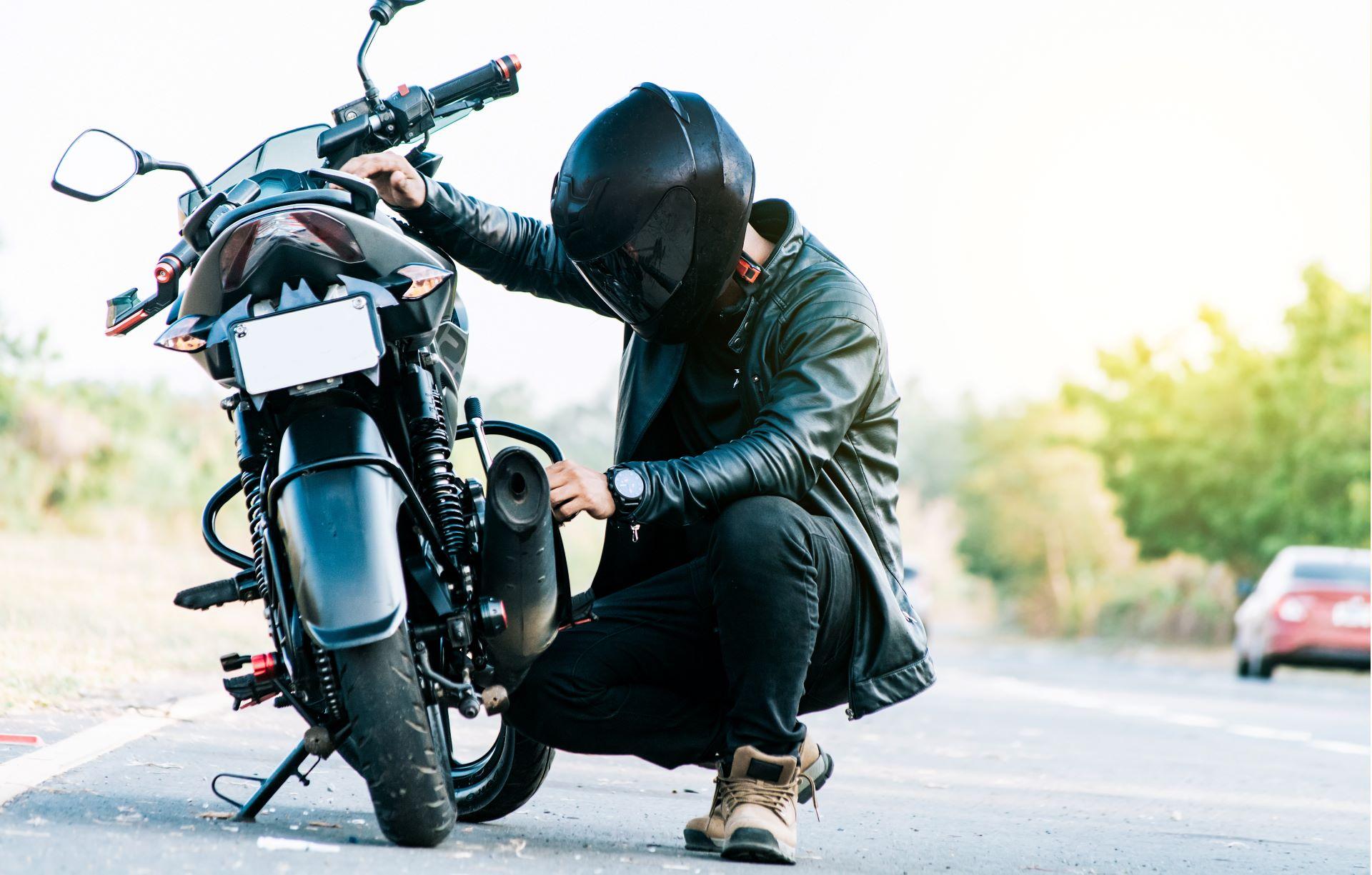 Motorradfahrer prüft Bauteile vor der Fahrt