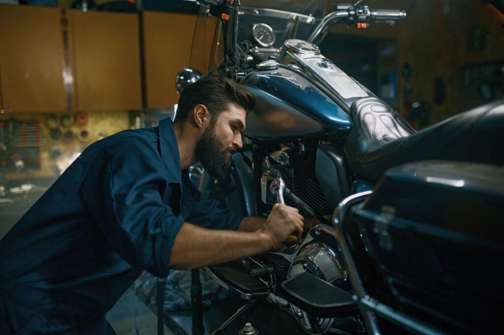 Mechaniker arbeitet an Motorrad mit Sturzbügel in Werkstatt