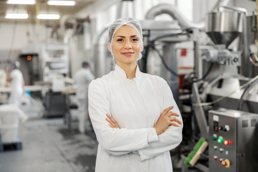 Frau in weissem Kittel in Lebensmittelproduktion | Lebensmittelschlauch
