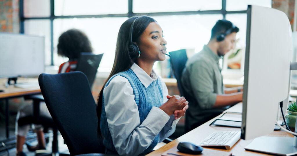 Online Seminarverwaltung im Supportteam – Mitarbeiterin kommuniziert digital mit Teilnehmenden in einer modernen Buero-Umgebung