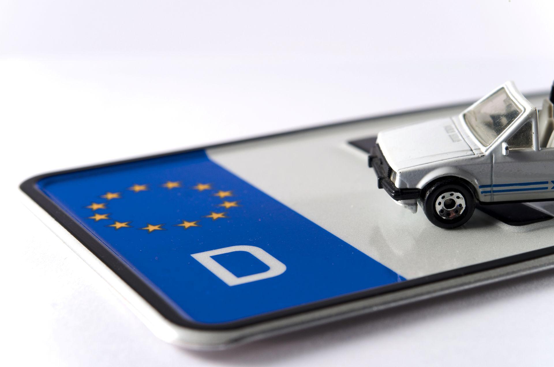 Modellauto steht auf einem deutschen Nummernschild mit EU-Kennung